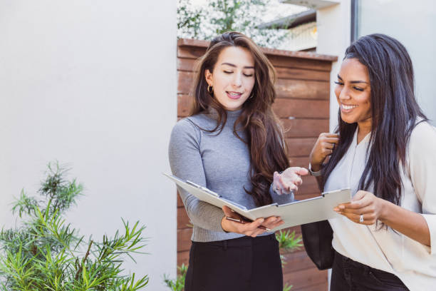 istock Female colleagues discuss paperwork before entering office 1291284600