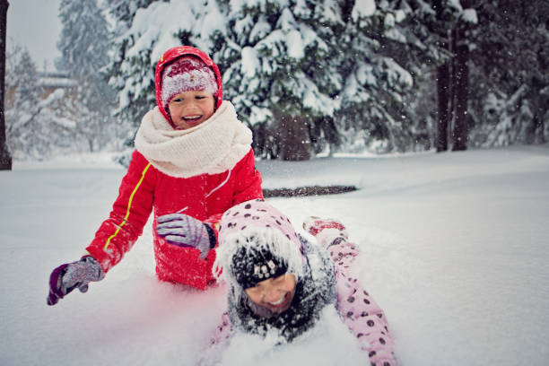istock Two girls are playing in the snow 1291284772