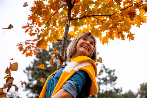 istock Woman under the maple tree in beautiful autumn day 1291285541