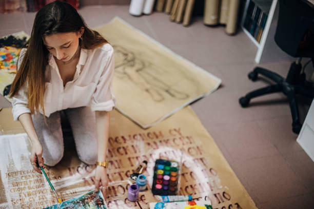 istock Female painter painting on the floor in art studio 1291286643