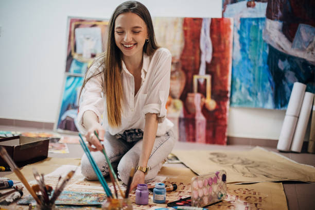 istock Female painter painting on the floor in art studio 1291286703