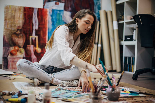 istock Female painter painting on the floor in art studio 1291286718
