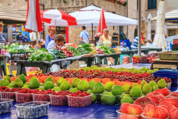 Photo of Summer cityscape - view of the fruit counter at the Gunduliceva Poljana Market in the Old Town of Dubrovnik