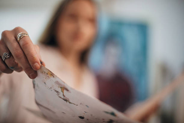 istock Female painter holding a messy painting 1291288012