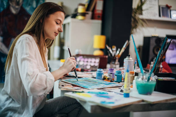 istock Young woman painting in her studio 1291288978