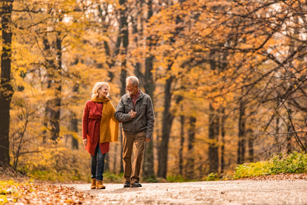 istock Senior couple walking together on a forest road. 1291290768