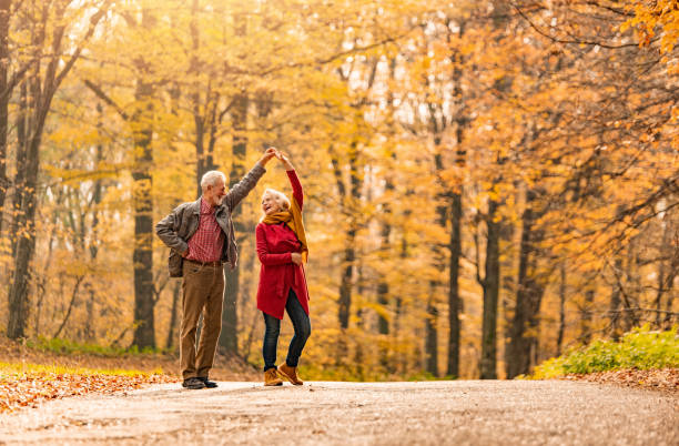 istock Playful romantic senior couple dancing on a forest road. 1291290841