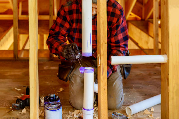 istock Plumber putting glue on the PVC drain pipe in the work area. 1291293183