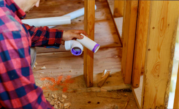 istock Plumber gluing sewage drain PVC pipes 1291293185
