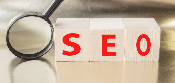 istock SEO search engine optimization text wooden cubes and magnifying glass on a Golden background. Idea, vision, strategy, analysis, Keyword and content concept 1291300118