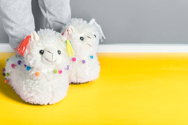 istock Young girl in cute soft 3d llama slippers 1291300228