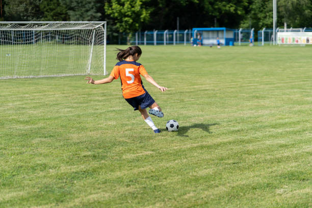 istock Female soccer player practices shots on goal on a turf field 1291300644