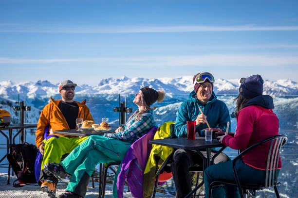 Group of friends enjoying apres-ski at top of Whistler mountain. stock photo