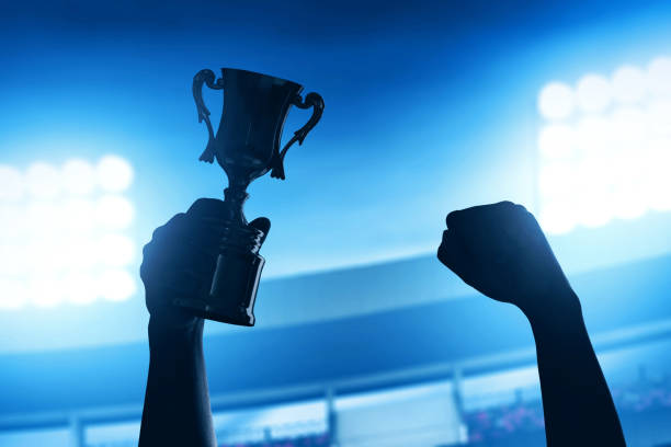 istock Man holding golden trophy cup 1291303775