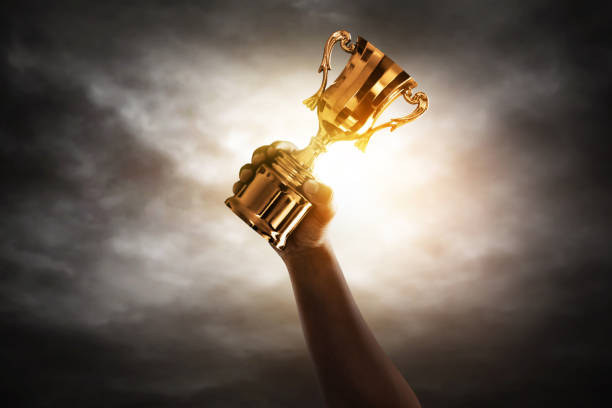 istock Man holding golden trophy cup 1291303782