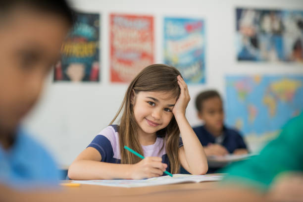 istock Caucasian girl student in classroom writing 1291308158