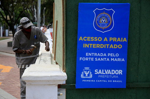 salvador, bahia, brazil - december 14, 2020: city hall worker interdicts Porto da Barra beach in the city of Salvador, due to the Covid-19 invention.