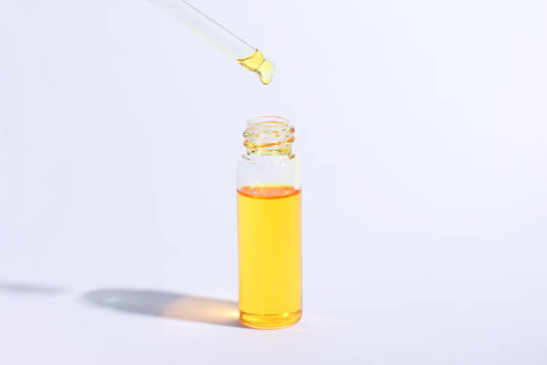 istock Oily drop falls from cosmetic pipette on light background 1291309635