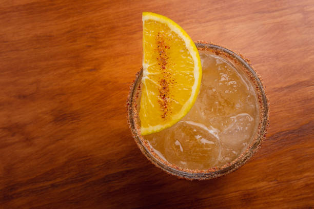 Fruit mixology with mezcal and orange slice on wooden table topper. Warm colored cocktails. Mezcal cocktail. Fruit mixology with mezcal and orange slice on wooden table topper. Warm colored cocktails. Mezcal cocktail. peyote cactus stock pictures, royalty-free photos & images