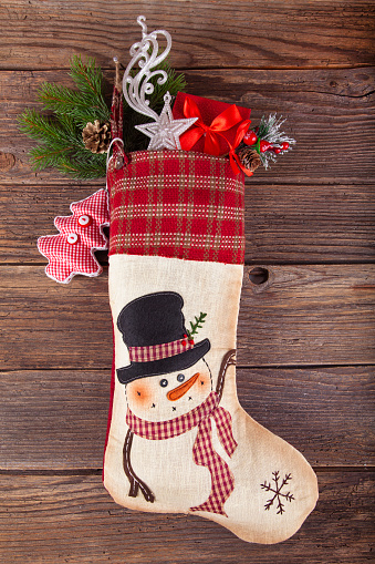 Christmas stocking Sock with Santa gifts on wooden background