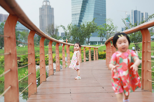 The little girls wear colorful dresses on a summer day, they were walking on the footpath