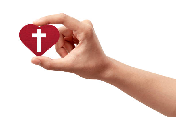 istock Human hand holding a red heart with a Christian cross 1291322155