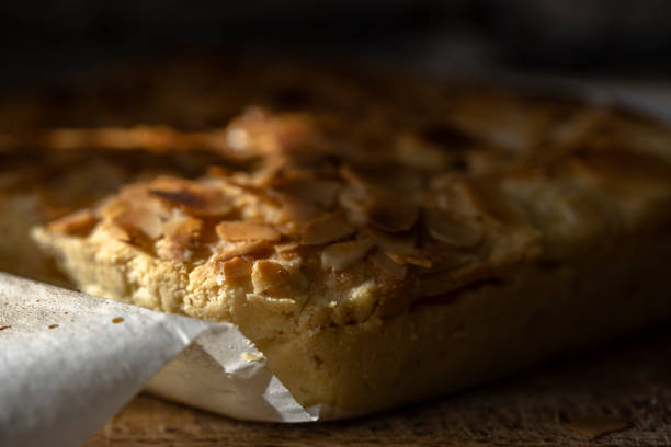 Golden-brown cookies piled together, adorned with crunchy nut toppings, laid artfully on a rustic wooden table. Their inviting aroma promises a delightful treat for any sweet tooth.