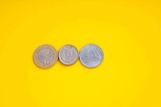 monete in valuta indiana su sfondo giallo - number 10 gold business paper currency foto e immagini stock