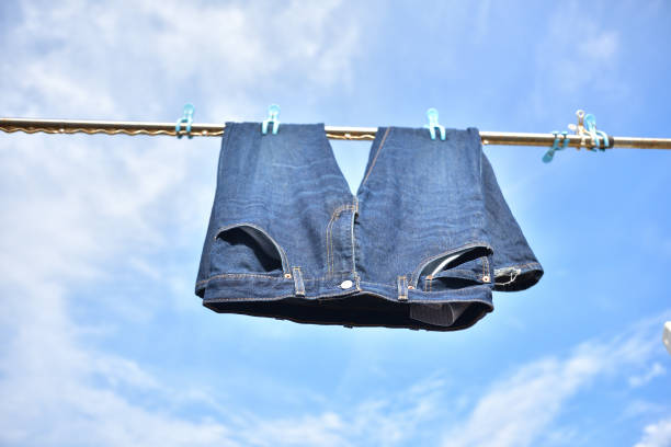 Scenery of hanging blue jeans on a clothesline on a sunny day
