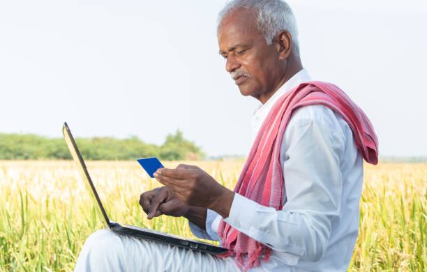 istock Indian farmer on laptop doing payment by using credit card - concept of rural people using technology, internet and lifestyle. 1291334341