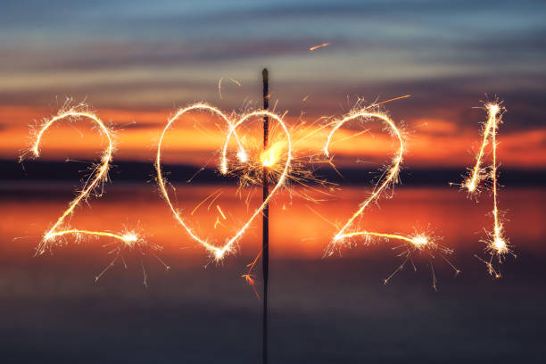 istock 2021 written with Sparkle firework on sunset background, happy new year 2021 concept. 1291334455