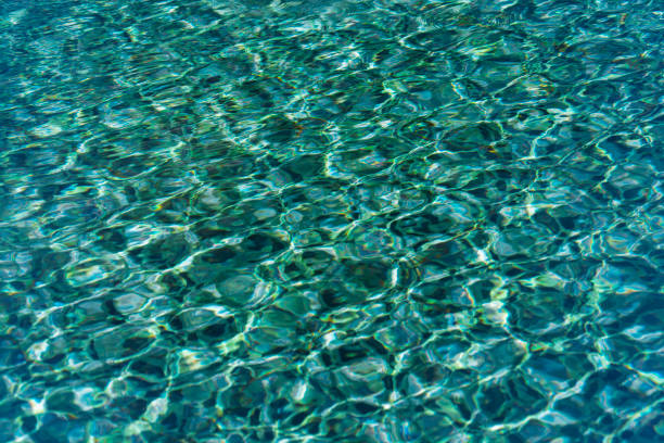 istock Pattern of wave on blue water swimming pool reflecting in the summer sun 1291334503