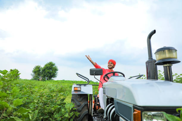 istock Indian farmer working with tractor at field 1291337843