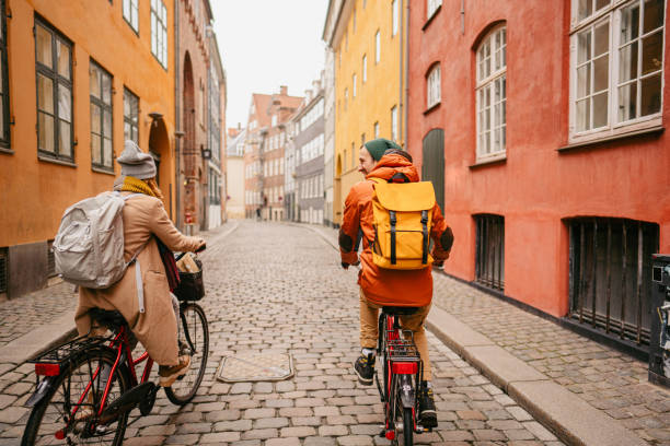 Couple enjoying the city ride Photo of a young couple riding bicycles and enjoying the lovely winter morning in the city. zealand denmark stock pictures, royalty-free photos & images