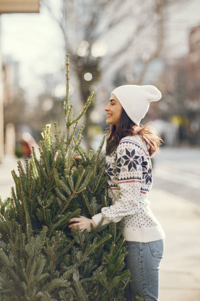 istock Cute brunette in a white sweater with Christmas tree 1291341305