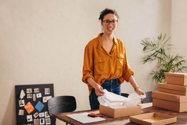istock Woman packing parcel boxes for customers at home office 1291342021