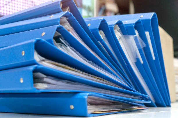 istock Business report blue stack binders folder for insert tax information paper document tag label and storage at offices sheles in organization management on busy desk office 1291344799