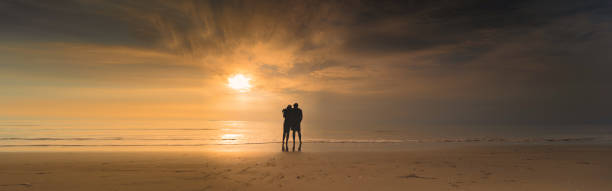 istock Silhouette Couple On Beach Against Sky During Sunset 1291345639