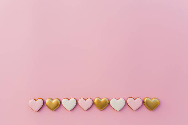 istock Pink background with sweet gingerbread heart cookies 1291345889