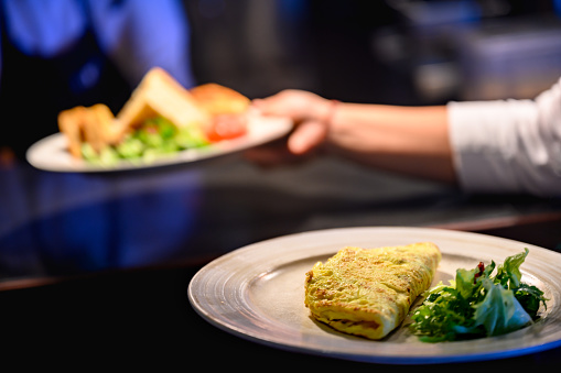 Unrecognizable wait staff serving omelet in a luxury restaurant, Nikon Z7