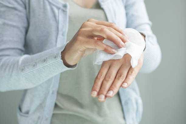 istock Woman cleaning her hands by using white tissue paper. isolated on a gray background. 1291347058