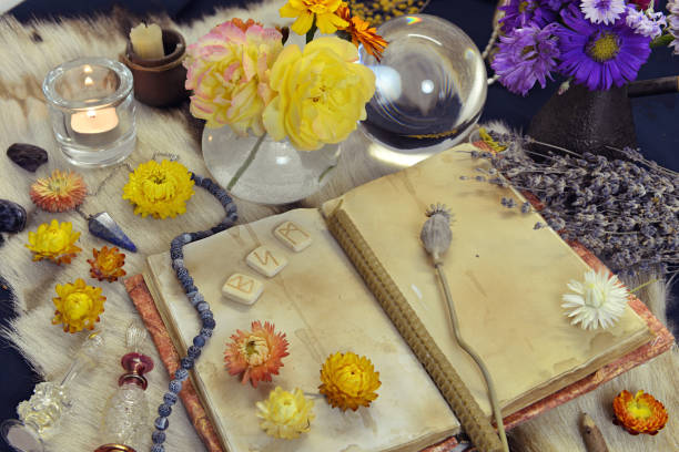 istock Still life with old book, runes, healing herbs and ritual magic objects on witch table. 1291347800