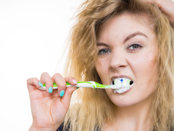 istock Woman brushing cleaning teeth 1291348998