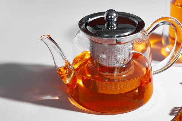 istock Glass teapot with fruit tea on table background 1291349584