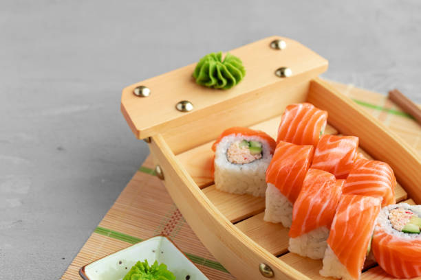 istock Sushi roll covered with fresh salmon served on plate 1291349696