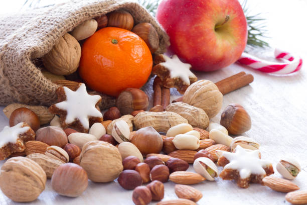 noci, frutta e biscotti in sacco di iuta, sfondo naturale del cibo natalizio - peanut bag nut sack foto e immagini stock