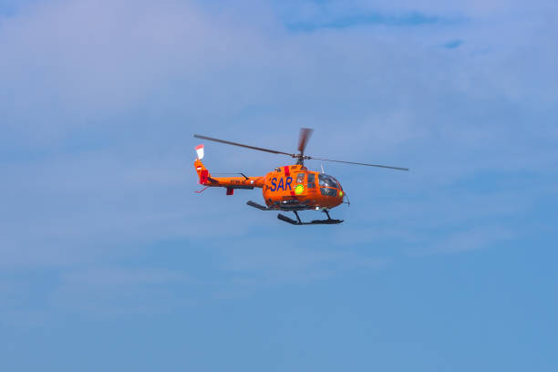 a search and rescue helicopter sar (search & rescue) in the sky over the coast of bali island, indonesia - rescue helicopter water searching imagens e fotografias de stock