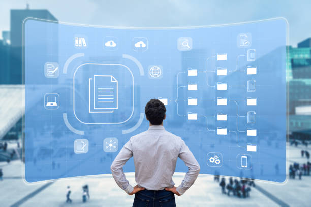 istock Document Management System (DMS) used to archive, search and manage corporate files and information in enterprise along business processes. Concept with manager looking at screen 1291353426