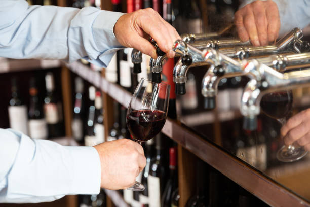 istock Bartender hand pouring draught red wine to glass 1291355230