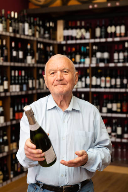 istock Attentive elderly man chooses champagne in a liquor store 1291355238
